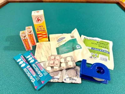 a table with a pair of scissors and some medicines at Simee Cozy Homestay ,Simee, Ipoh Town in Ipoh
