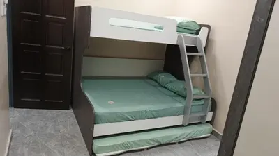 a bunk bed with a ladder in a room at Lapangan Sentosa Homestay Ipoh in Ipoh