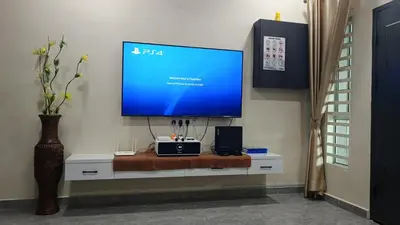 a flat screen tv sitting on top of a white cabinet at Lapangan Sentosa Homestay Ipoh in Ipoh