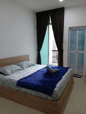 a bedroom with a bed with a blue blanket and a window at Ereens penthouse Cameron highland in Brinchang