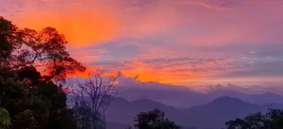 a sunset with a rainbow in the sky over mountains at B43A2 Silverpark Resort Best Mountain view Walk up 1 floor in Bukit Fraser
