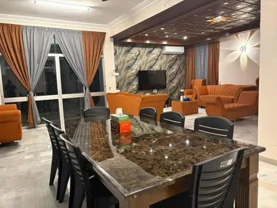 a living room with a large table and chairs at 786 Bali Top Homestay in Sungai Petani
