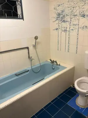 a bathroom with a blue tub and a toilet at 786 Bali Top Homestay in Sungai Petani