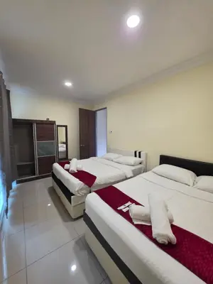 a hotel room with three beds in a room at Teeview Homes in Tanah Rata