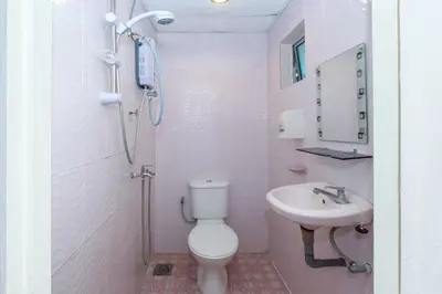 a white bathroom with a toilet and a sink at OYO 89984 Noris Wang Homestay in Kampong Banjar