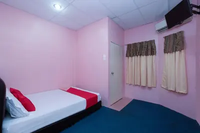 a small room with a bed and a tv at OYO 89984 Noris Wang Homestay in Kampong Banjar
