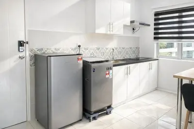 a kitchen with white cabinets and a refrigerator at Anderson Apartment by LUMO LIMA in Ipoh