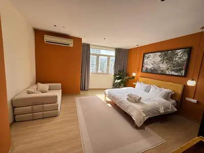 a bedroom with a bed and a couch in it at Penang Stay 2-6px Convenient Free parking in George Town