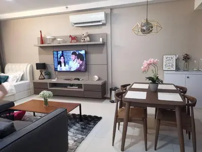 a living room with a couch and a table and a tv at Premier Suite Seaview 3 minute to gurney in Gua Sai