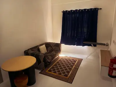 a living room with a chair and a table at IFS Soho 3 Basic Home in Seri Iskandar