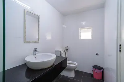 a white bathroom with a sink and a toilet at 2BR Maritime Suite Duplex George Town SeaView in George Town