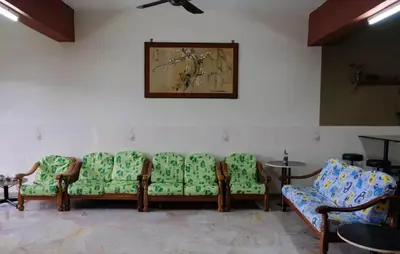 a waiting room with green chairs and a table at Taiping Lake View in Gua Sai