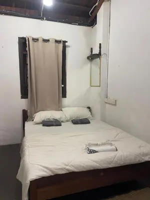 a bedroom with a large bed with white sheets at Pearl Heritage Guesthouse in George Town