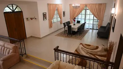 a living room with a table and a dining room at BUNGALOW POOL, NETFLIX, BBQ And BATU FERRINGHI in Batu Ferringhi