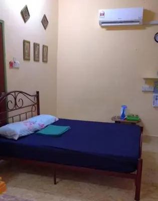 a bedroom with a blue bed in a room at Roomstay Zai Sungai Klah in Kampung Jeram Kawang