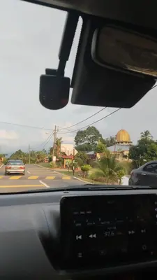 a view from the dashboard of a car driving down a street at Roomstay Zai Sungai Klah in Kampung Jeram Kawang