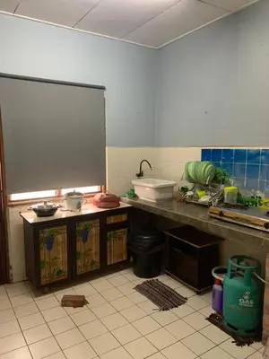 a kitchen with a table and a counter top at Adila Homestay in Seri Iskandar