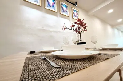 a table with plates and glasses and a plant on it at K Room Homestay at Taiping in Taiping