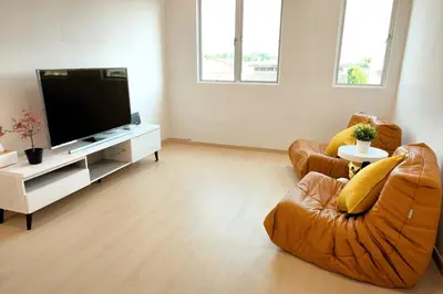 a living room with two chairs and a flat screen tv at K Room Homestay at Taiping in Taiping