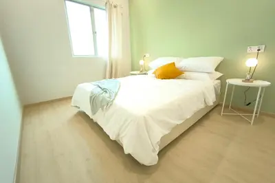 a white bed in a room with a window at K Room Homestay at Taiping in Taiping