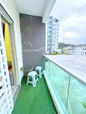 a balcony with two stools and a table on a building at THE QUINTET BY D Atas Bukit Antarium in Tanah Rata