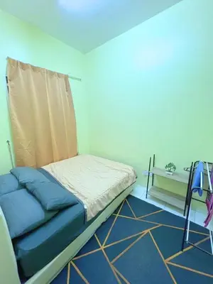 a small bed in a room with a blue wall at THE QUINTET BY D Atas Bukit Antarium in Tanah Rata