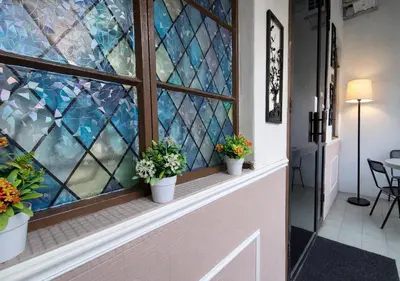 a window with three potted plants on a window sill at MediSehat KamarKu - Just 20 meters to Gleneagles Hospital Penang in George Town