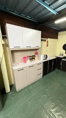 a large kitchen with white cabinets in a room at Laman Warisan Opah Homestay in Manong