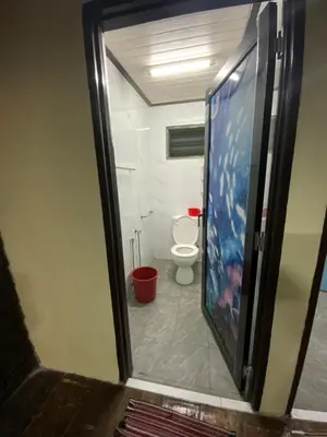 a bathroom with a toilet and a large screen television at Laman Warisan Opah Homestay in Manong