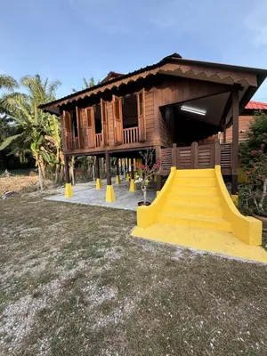 a house with a staircase in front of it at Laman Warisan Opah Homestay in Manong