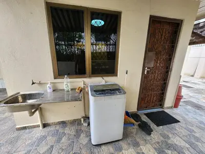 a trash can and a sink in front of a building at House of Lights in Batu Gajah