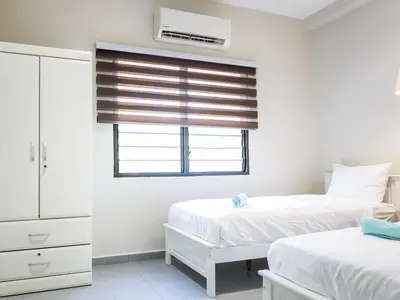 a bedroom with two beds and a window with a blind at Cozy Corner PataniRoad 14 pax Georgetown in George Town