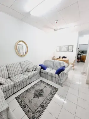 a living room with two couches and a mirror at Homestay Taman Segar for musleem in TanjongMalim