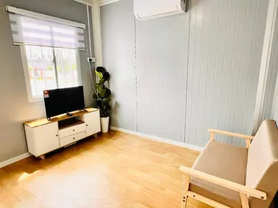 a living room with a tv and a chair at Rossaliya Cottage in Taiping