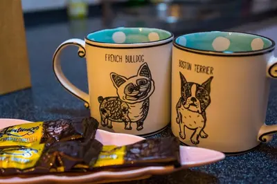 two coffee mugs sitting next to a plate of food at Spacious 4BR Corner with Pool Table in Ipoh