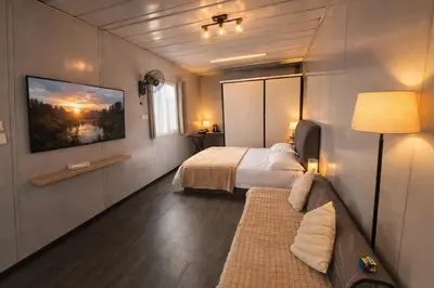 a bedroom with a bed and a tv and a couch at Galaxy Homestay in Ipoh