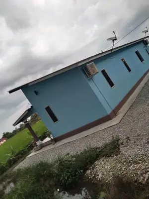 a blue building with windows on the side of it at Aziyaa Homestay rumah no1 in Sungai Besar