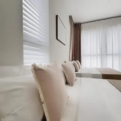 a white bedroom with a couch and a window at The Urban Suites City&seaview in Jelutong