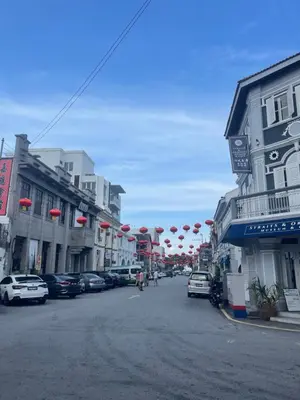 a street in a town with buildings and red umbrellas at Pearl Heritage Homestay in George Town