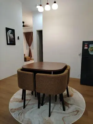 a wooden table and chairs in a room at Risfeena Home in Sekincan