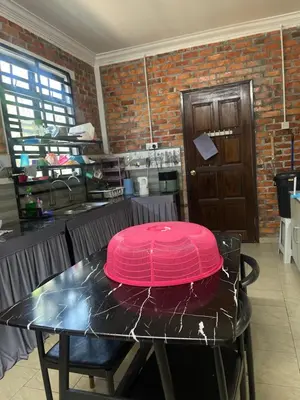 a pink lid on a table in a kitchen at Homestay Anjang in Tapah