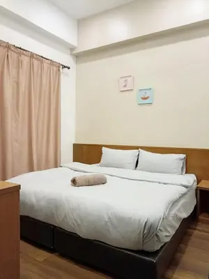 a bedroom with a large bed with white sheets at Bayt Rizq Homestay 3R2B in Brinchang
