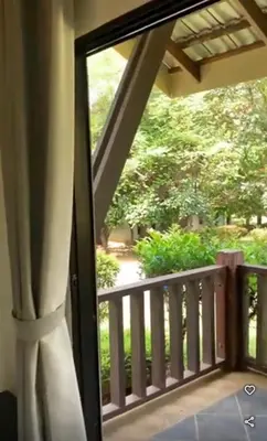 a balcony with a view of a yard at Eds Hot Spring Villa's in Sungkai