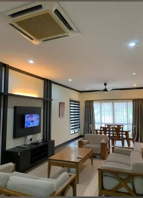 a living room with a couch and a tv and a table at Eds Hot Spring Villa's in Sungkai