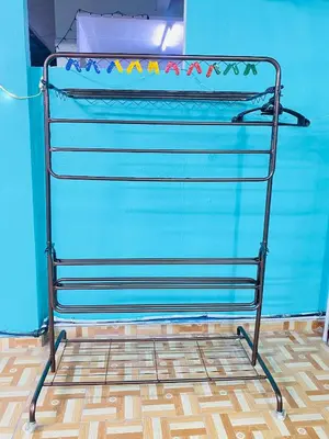 a metal towel rack in front of a blue wall at Homestay Sayang in Ipoh