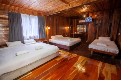 a bedroom with two beds and a television in it at Joe Fisherman Inn in Pangkor