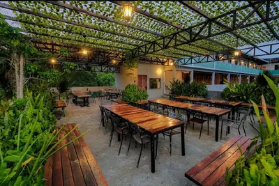 an outdoor patio with tables and chairs and a pergola at Joe Fisherman Inn in Pangkor