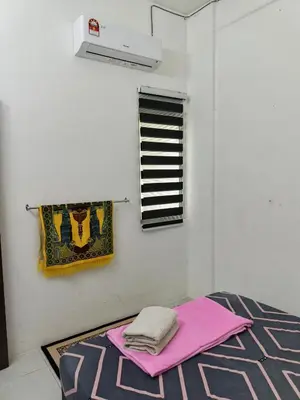 a room with a bed with pink sheets and a window at Seri Homestay Apartment Seri Iskandar in Seri Iskandar