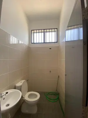 a bathroom with a toilet and a sink and a window at HSKeladanImpian in Gua Sai