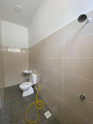 a bathroom with a toilet and a yellow hose at HSKeladanImpian in Gua Sai
